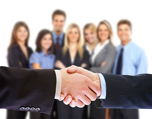 handshake with a customer in front of business team members